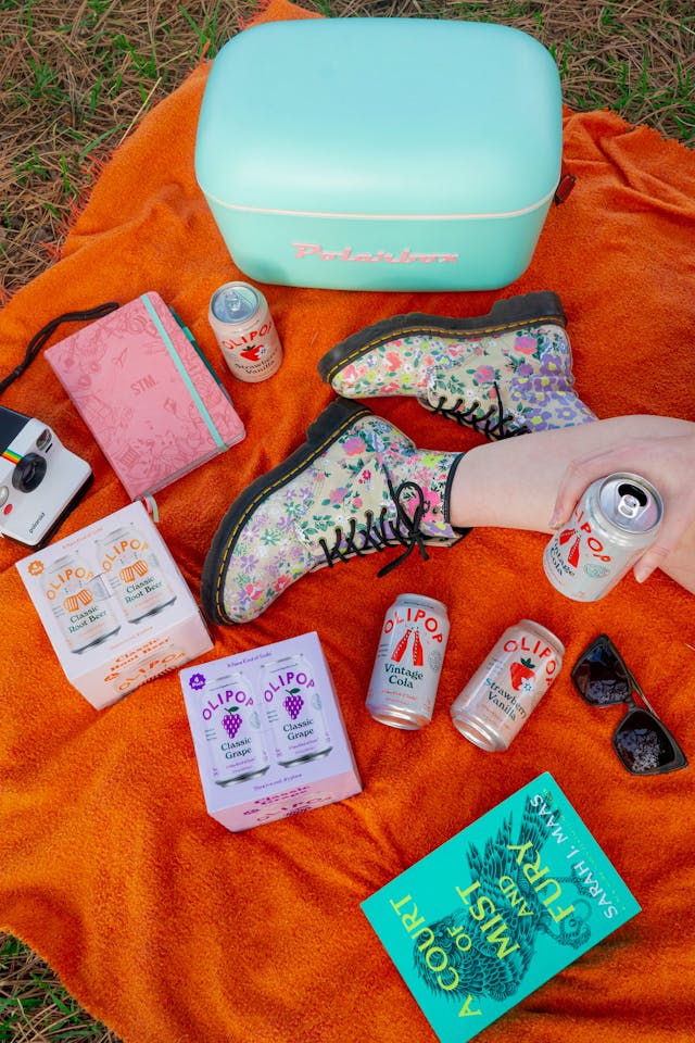 Traveler enjoying an Olipop soda while commuting with a backpack or suitcase